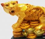 Tigras sėdi ant kalno su monetomis